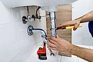 A man takes apart a drain.