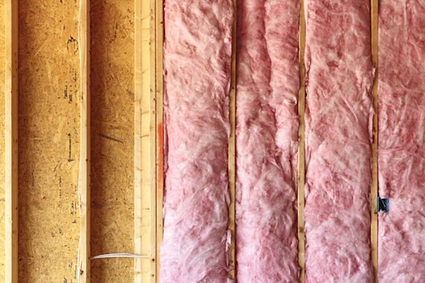 pink insulation in unfinished wall of plywood