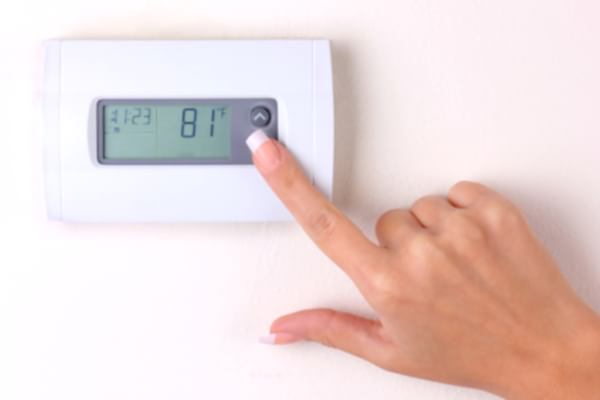 Woman programming digital thermostat