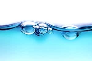 How does the air bubble in the water create the "plinking" sound after a water drop collides with other water?