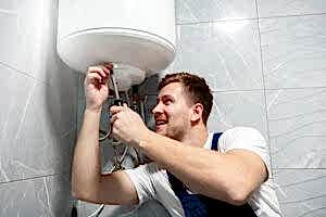 person repairs a leaking water heater.