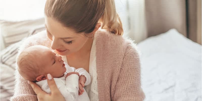 Woman with newborn baby in a bright home