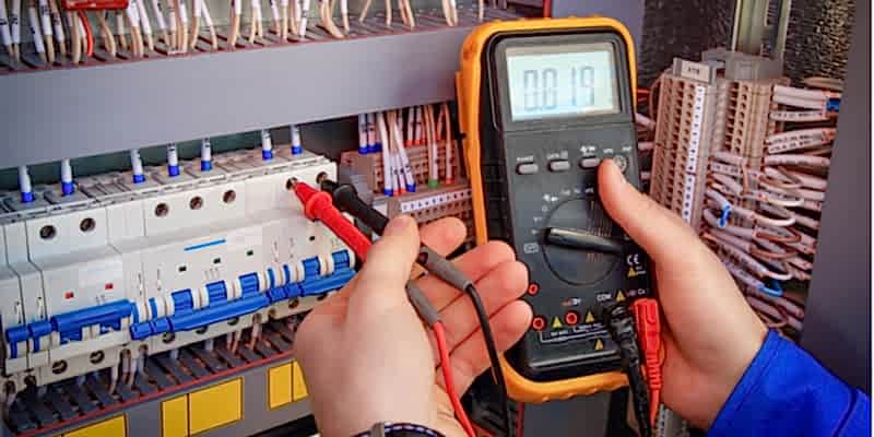 Electrical multimeter plugged into a fixture to measure voltage