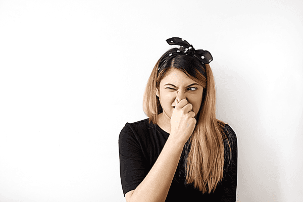 Woman holding her nose after smelling stinky plumbing problems