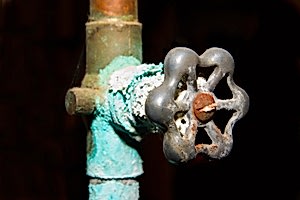 A copper pipe covered in blue corrosion.